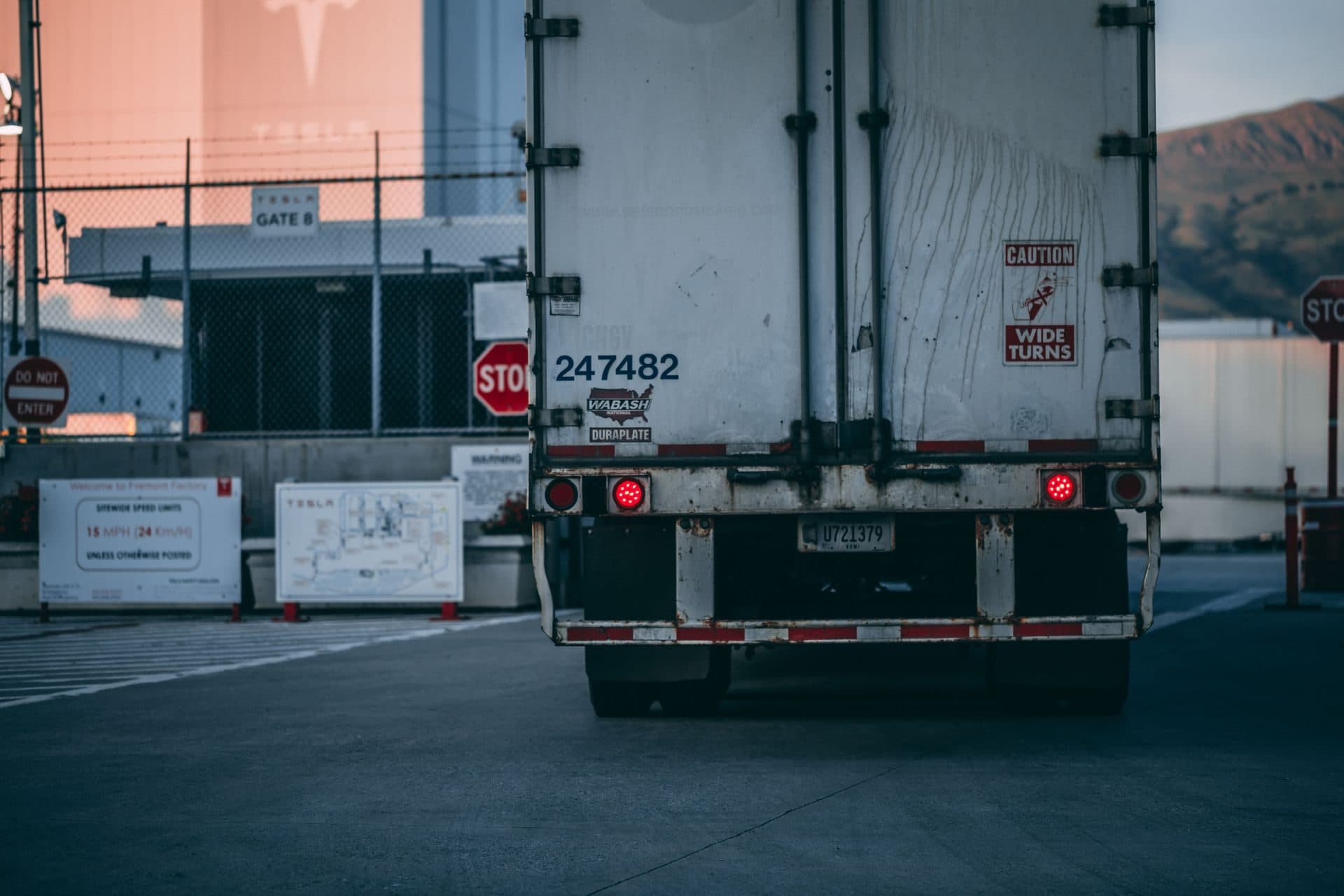 Rear swing doors of a white dry van backed up to a loading dock