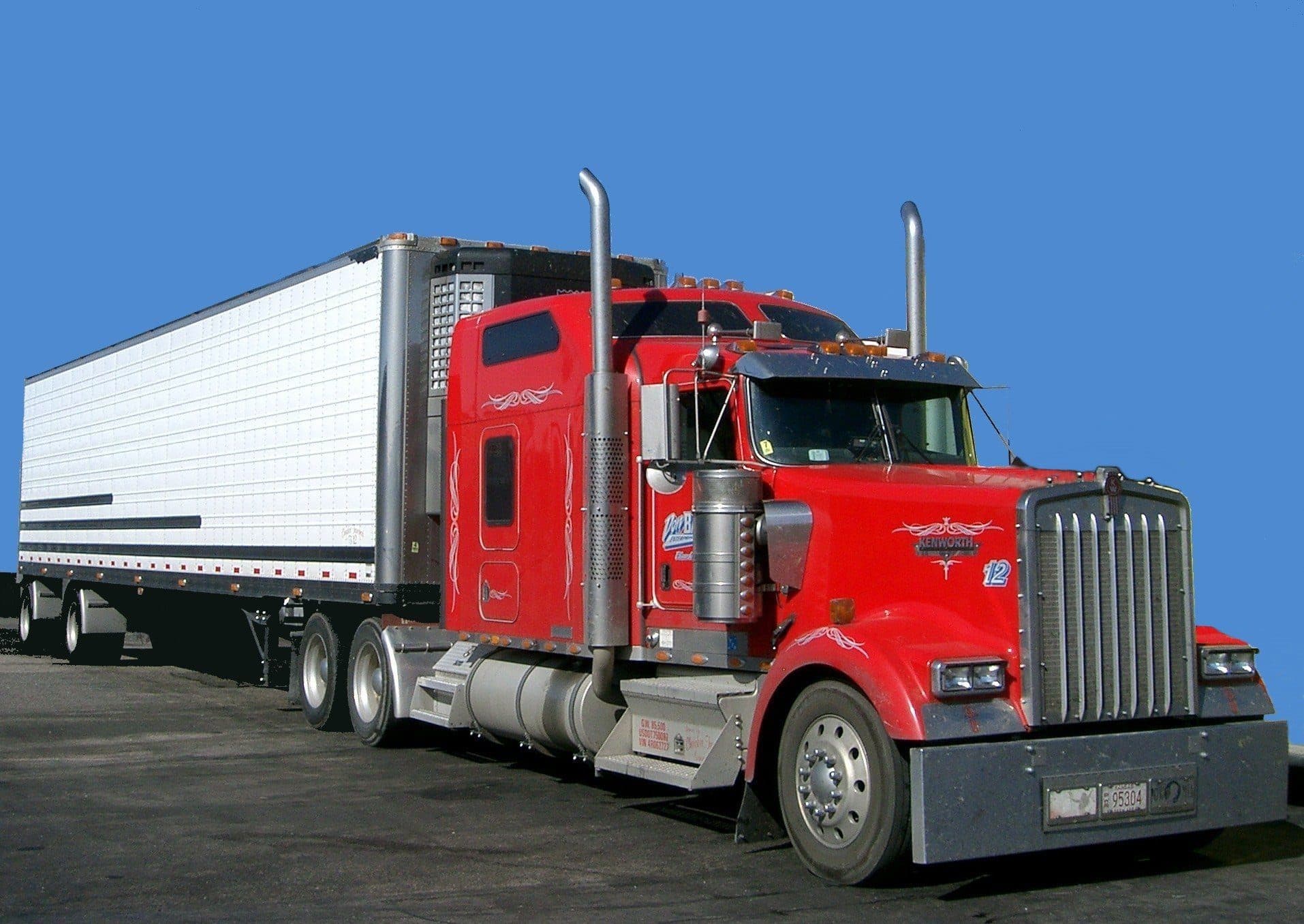 Red long-nose tractor coupled to a white 53-foot refrigerated trailer with nose-mounted reefer unit