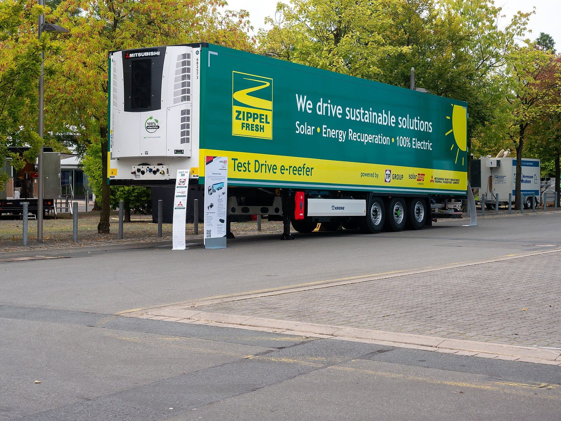 Green-liveried refrigerated trailer with an electric refrigeration unit on display